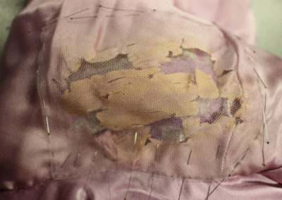 Image shows deteriorated silk supported onto dyed nylon net, and then covered with a protective layer of the same net