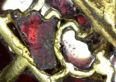 Individual garnet being repositioned in gold cell